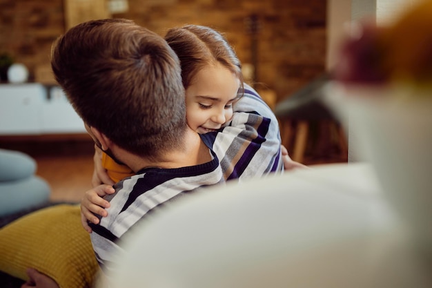 Figlia felice che abbraccia suo padre a casa