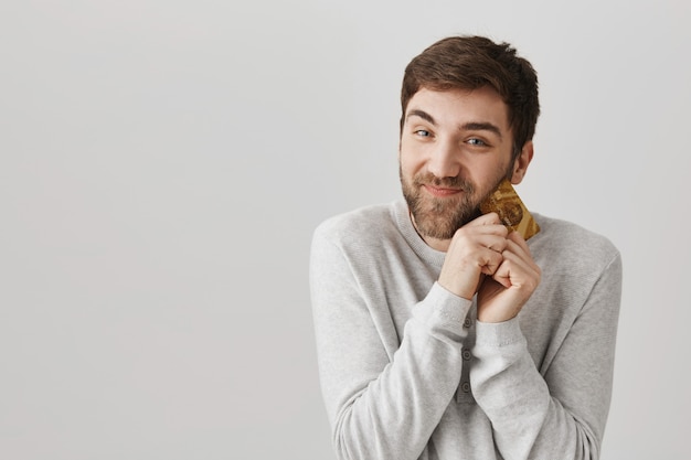 Happy delighted bearded guy hugging cold credit card