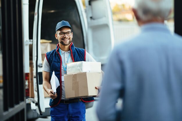 顧客への宅配をしながら荷物を運ぶ幸せな配達人