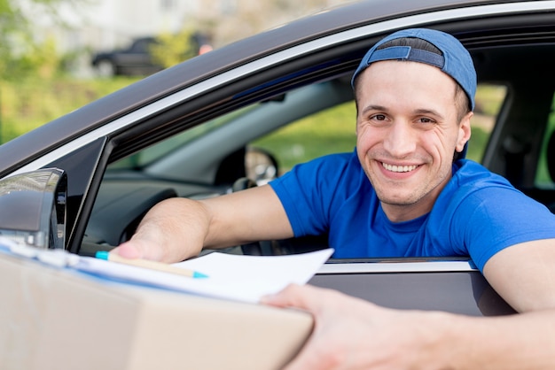 Happy delivery guy holding box