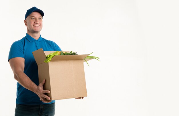 Happy delivery man holding grocery box