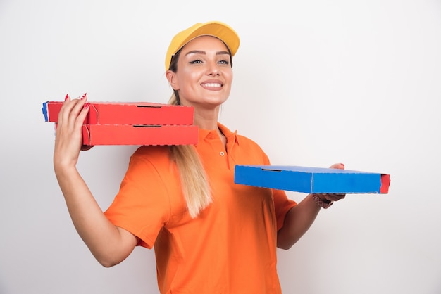 Happy delivery woman holding pizza boxes.