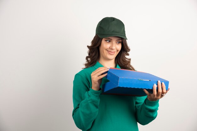 Happy delivery woman opening pizza box.
