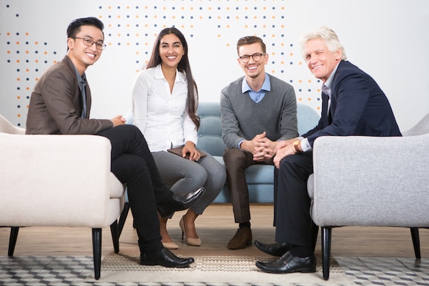 Happy Diverse Business Partners Sitting in Lounge