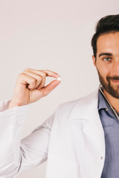 Happy doctor posing with a pill