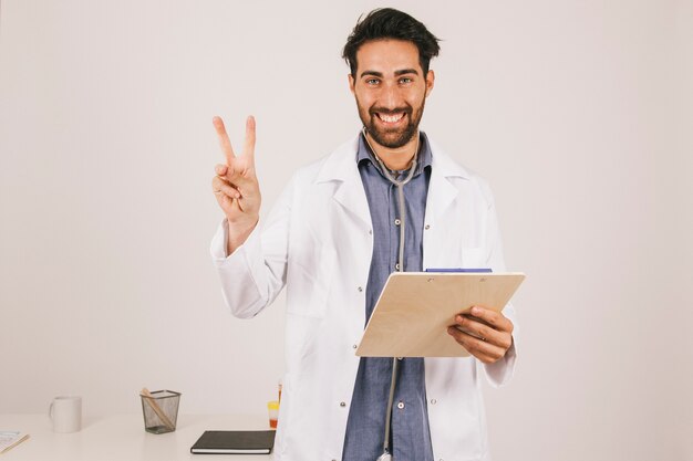 Free photo happy doctor with clipboard celebrating victory