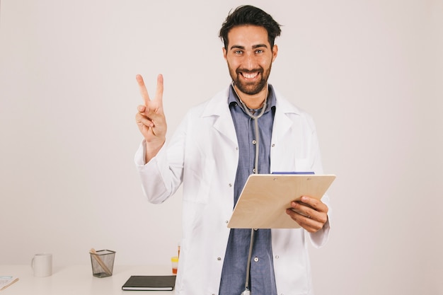 Happy doctor with clipboard celebrating victory 