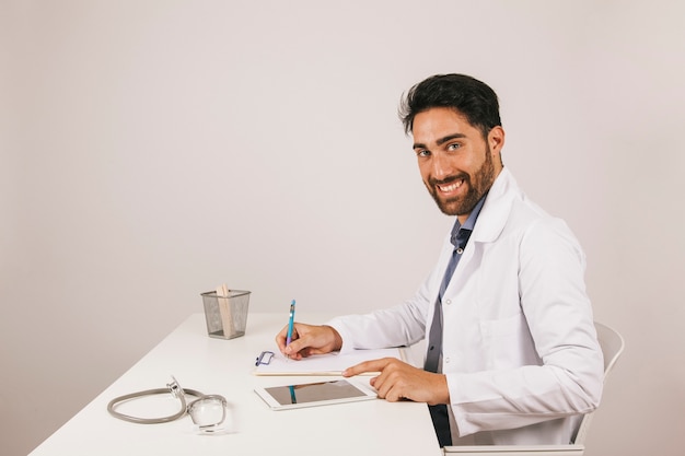 Free photo happy doctor with tablet in the office