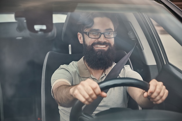 Счастливый водитель с пристегнутым ремнем безопасности