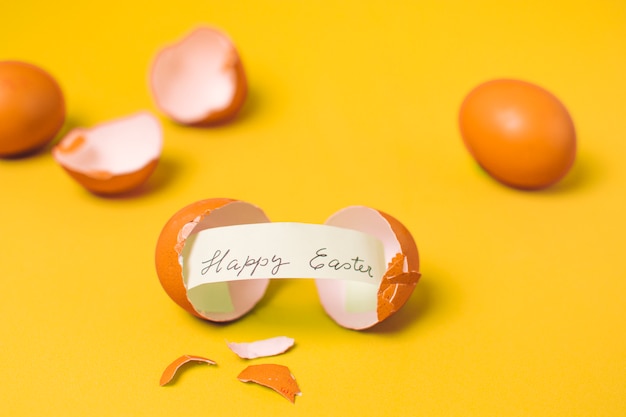 Free photo happy easter inscription on paper between shell