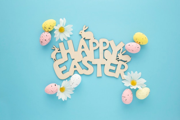 Happy Easter sign with eggs and daisies on a blue background