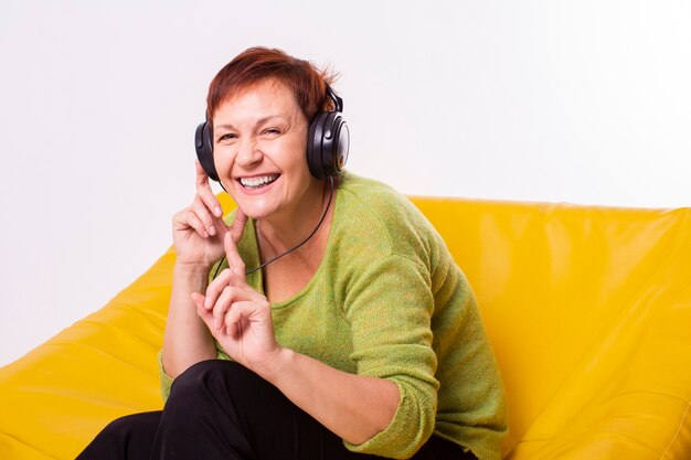 Happy elder listening music on headphones