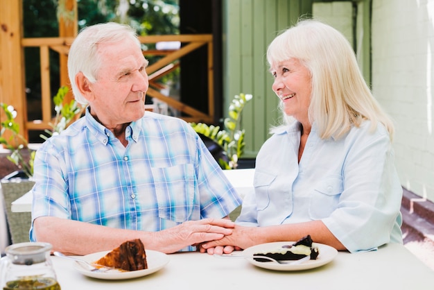 Happy elderly couple eating cake