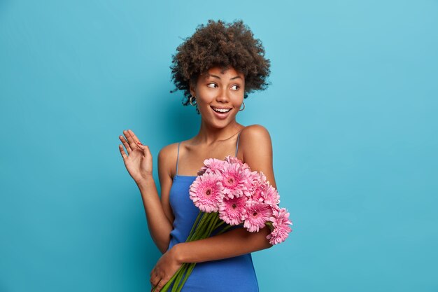 Happy elegant nice woman with bouquet of pink gerbera daisy, gets flowers