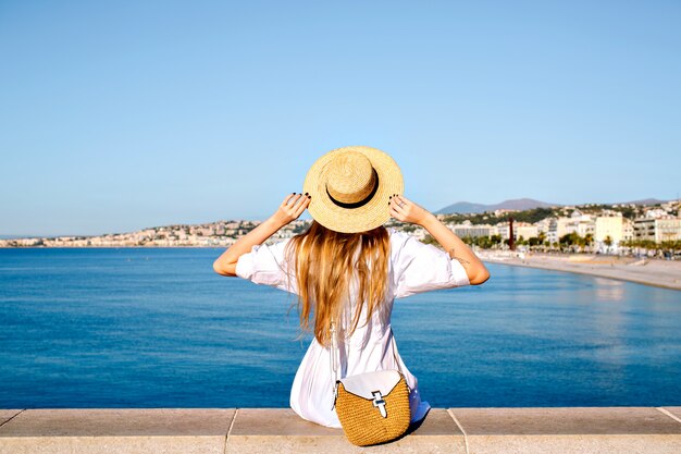 Happy elegant woman posing back, put her hand in the air and enjoying amazing view in France