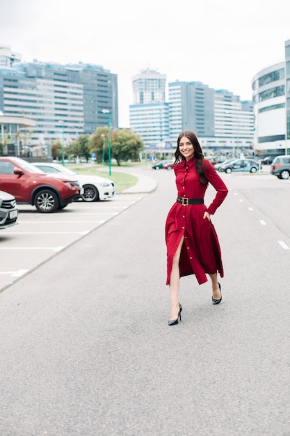 Felice donna elegante in rosso sulla strada