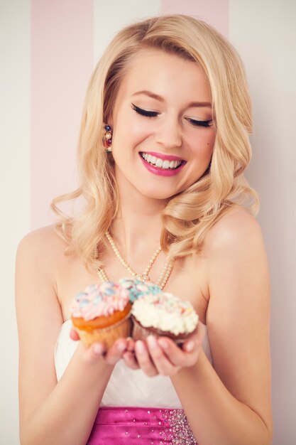 Happy elegant woman with muffins