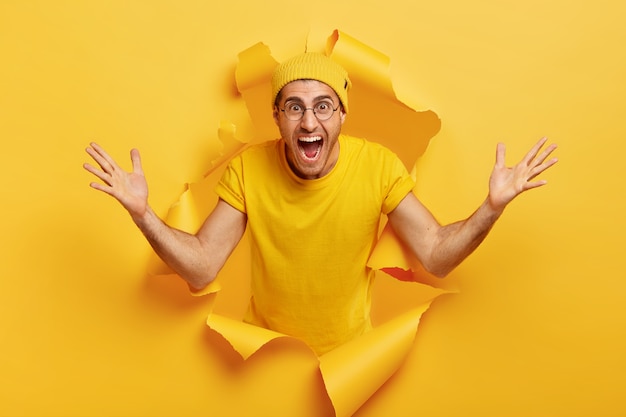 幸せな感情的な白人男性は巨大なジェスチャーを示し、何か大きなものを測定します