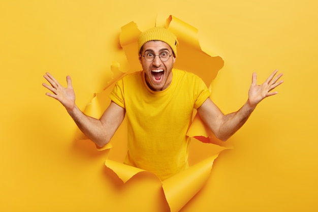 Happy emotional Caucasian man shows huge gesture, measures something big