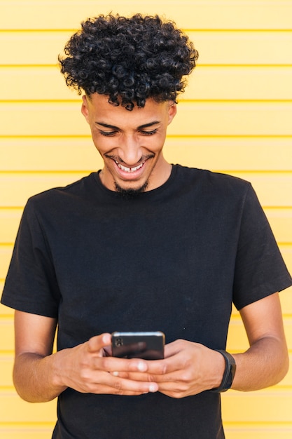 Happy ethnic male browsing phone