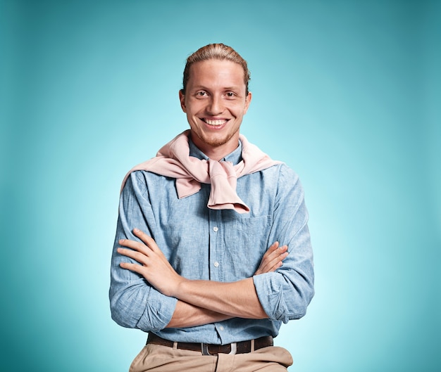 Happy excite young man smiling over blue background