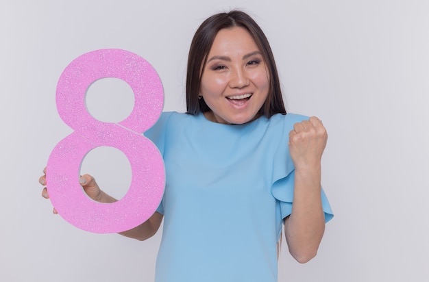 Free photo happy and excited asian woman holding number eight made from cardboard