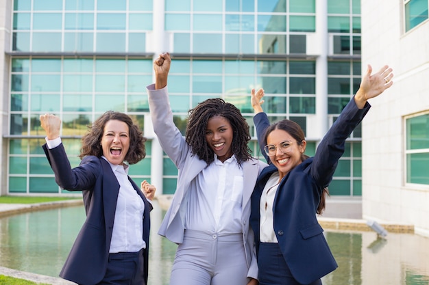 Happy excited businesswomen rejoicing at corporate success