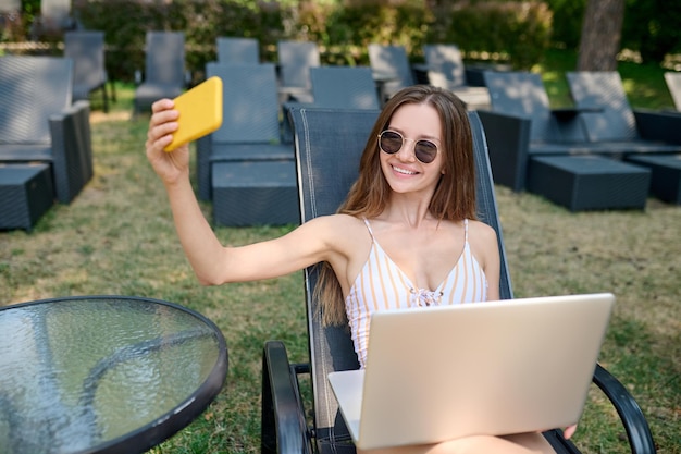 Happy excited young woman making selfie
