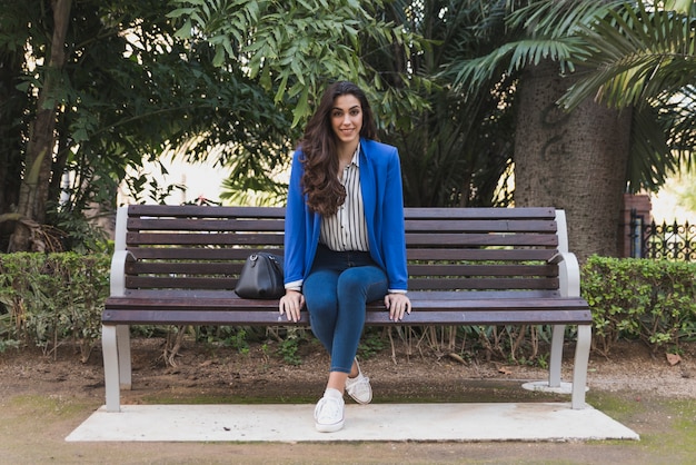 Happy executive resting on a park bench