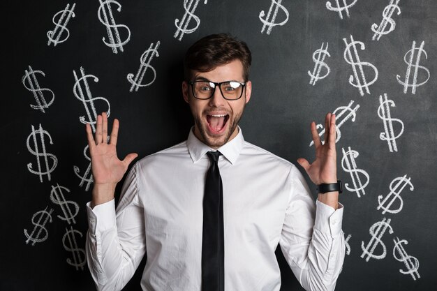 Happy exited attractive man in glasses standing with opened palms, 