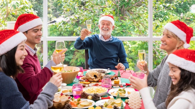 크리스마스 휴가를 함께 축하하기 위해 함께 저녁 식사를 하는 행복한 확장된 다세대 가족