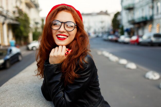 Happy fabulous ginger woman in stylish red beret in the street