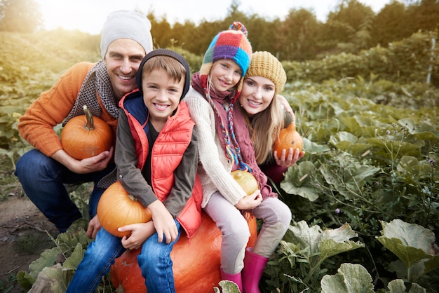 Famiglia felice nel campo pieno di zucca