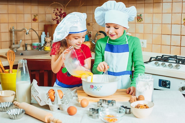 счастливая семья прикольные дети готовят тесто, пекут печенье на кухне