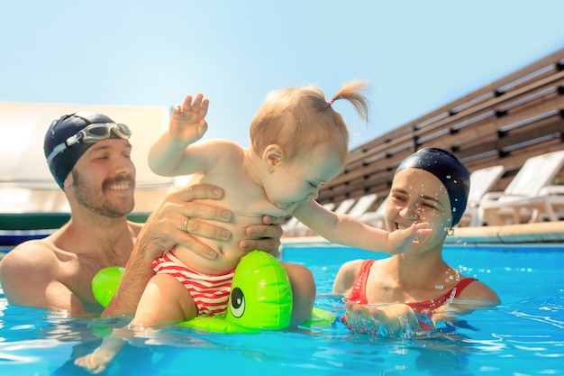 Счастливая семья веселится у бассейна
