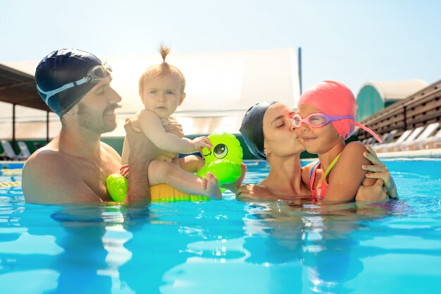 Happy family having fun by the swimming pool