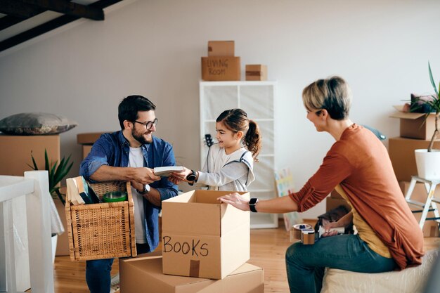 Happy family having fun while unpacking their belongings in a new apartment