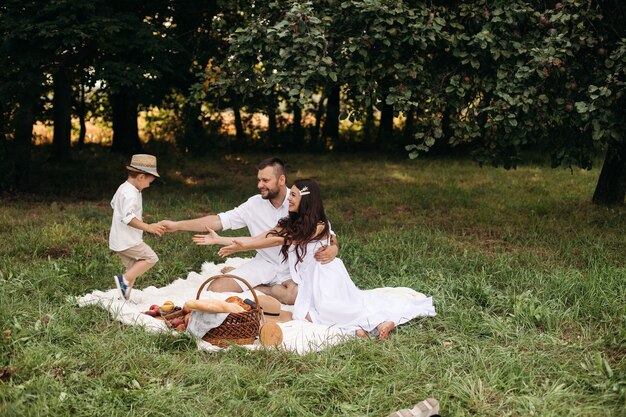Счастливая семья, пикник на открытом воздухе со своим милым сыном