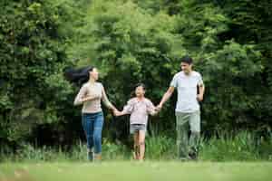 無料写真 幸せな家族が楽しんでいます母、父と娘が公園で走っています。