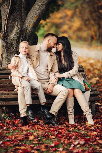 A happy family is walking in the park mom dad and son are chatting and walking a stylish family pare