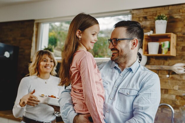 Happy family in the kitchen Focus is on father and daughter talking to each other