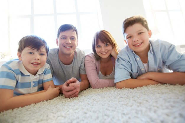 Happy family lying down on a white carpet