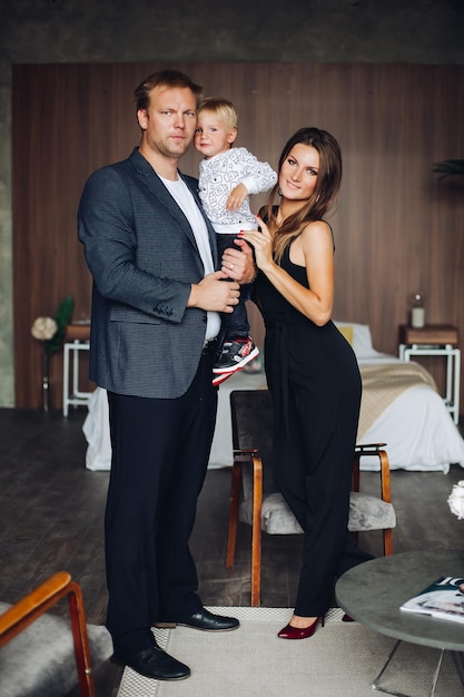 Happy family mother and father playing with a baby at home