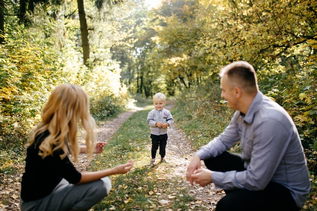 秋の公園で遊んで笑う幸せな家族