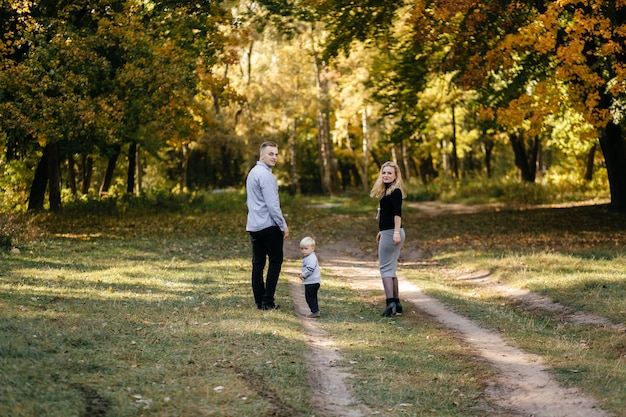 Famiglia felice giocando e ridendo nel parco in autunno