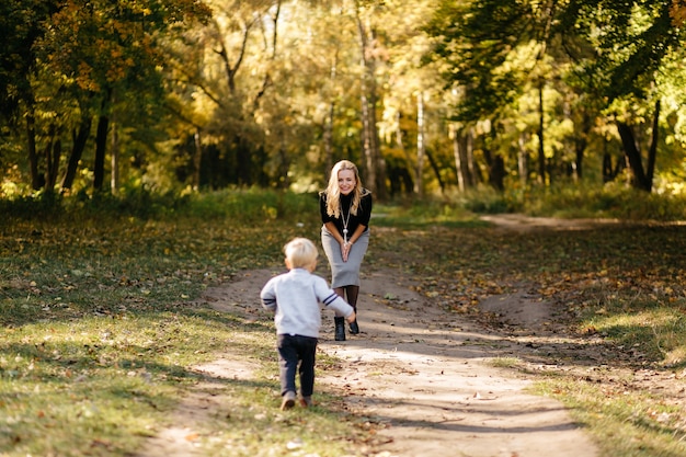 Famiglia felice giocando e ridendo nel parco in autunno