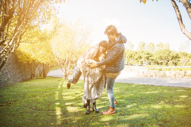 Foto gratuita famiglia felice che gioca nel parco il giorno soleggiato