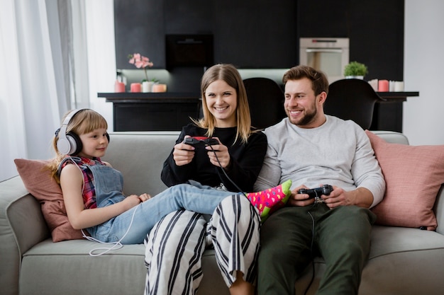 Happy family playing video games on couch