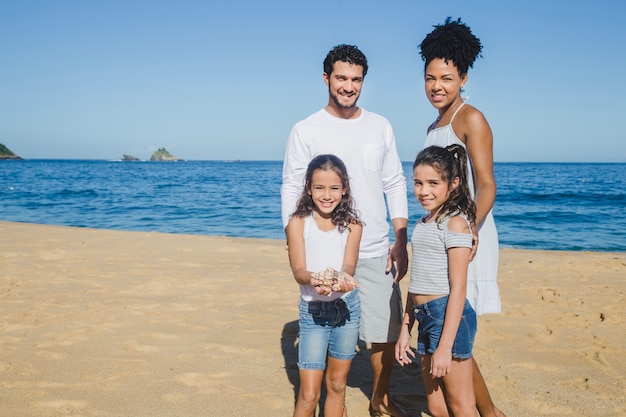 在海滩上自由幸福的家庭在摆拍照片