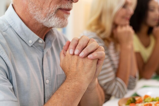 Счастливая семья молится перед ужином вместе